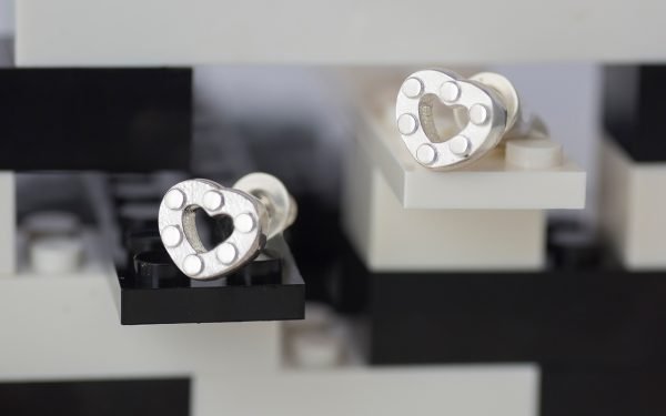 pair of silver heart earrings with lego design