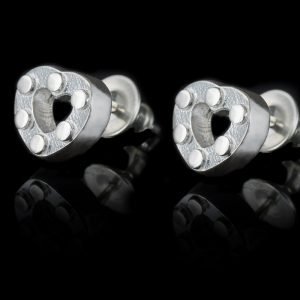 pair of silver heart earrings on black background