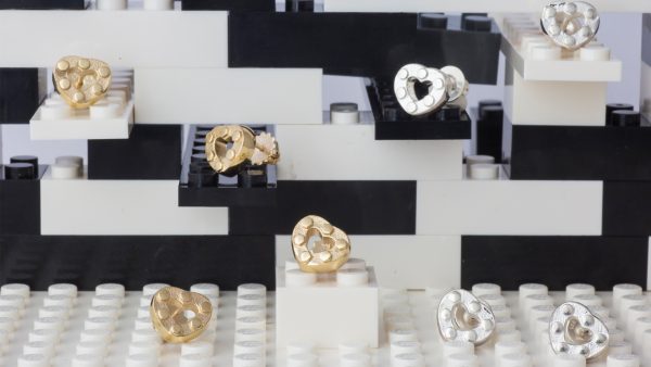 silver and gold heart earrings on lego bricks